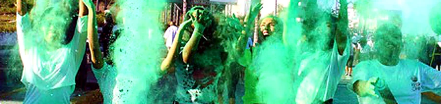 Participantes celebrando entre nubes de polvo verde